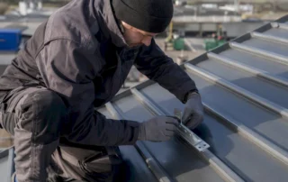 Un tecnico al lavoro per installare un impianto fotovoltaico sul tetto di un’azienda.