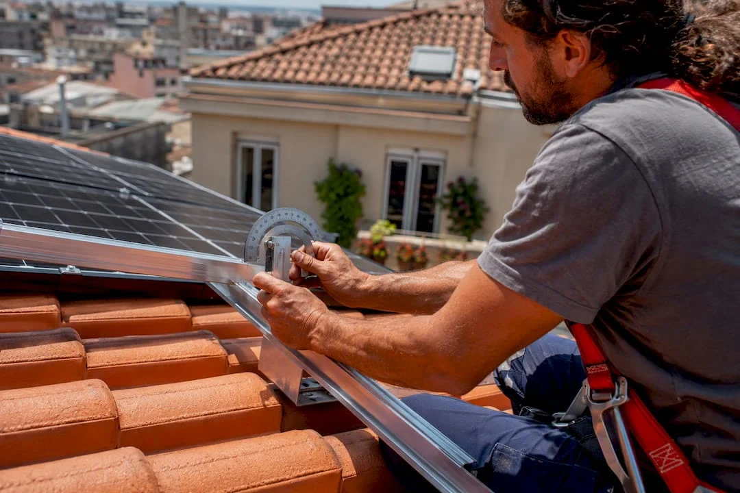 Mani che controllano l’inclinazione di un pannello solare installato sul tetto
