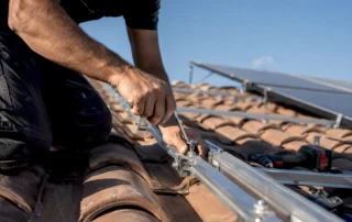Tecnico che regola il supporto del pannello solare sul tetto