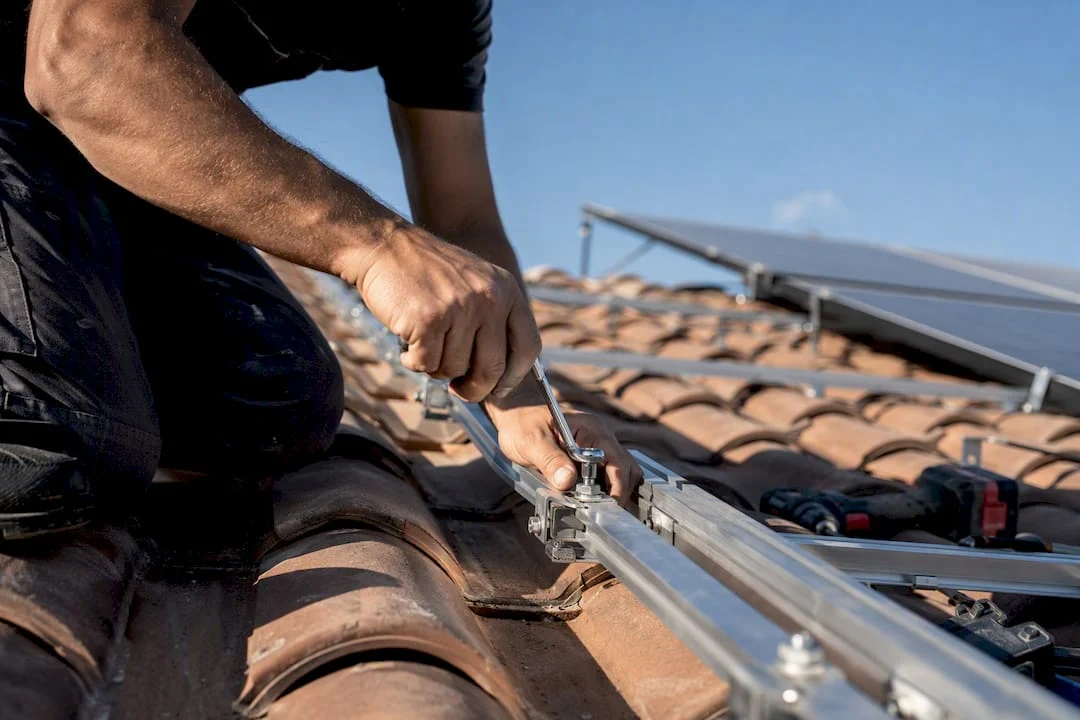 Tecnico che regola il supporto del pannello solare sul tetto