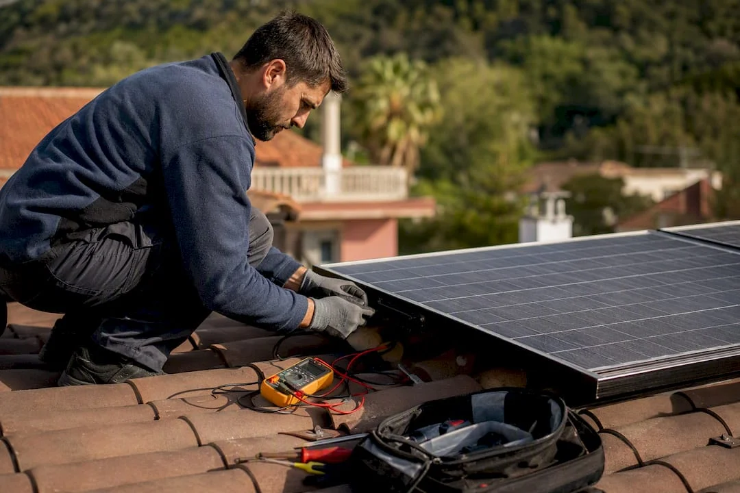 Tecnico che controlla un pannello solare sul tetto