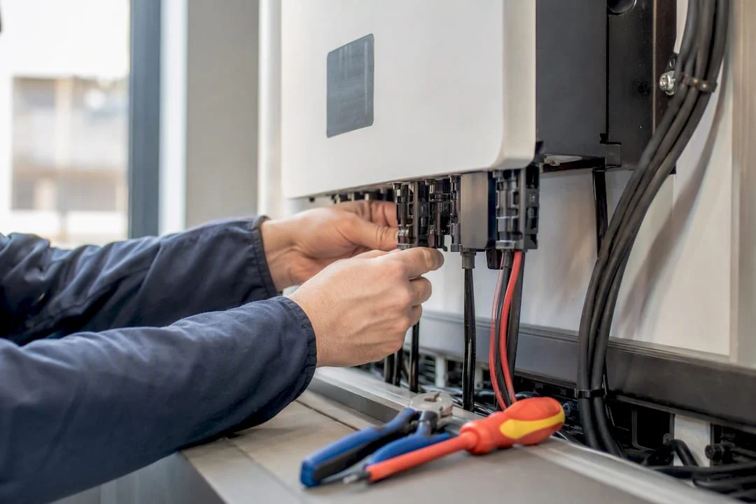 Mani che regolano i collegamenti dell'inverter fotovoltaico