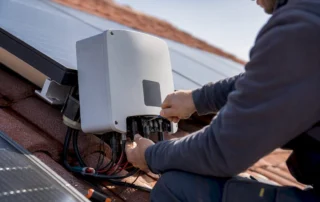 Tecnico che regola un inverter trifase sul tetto