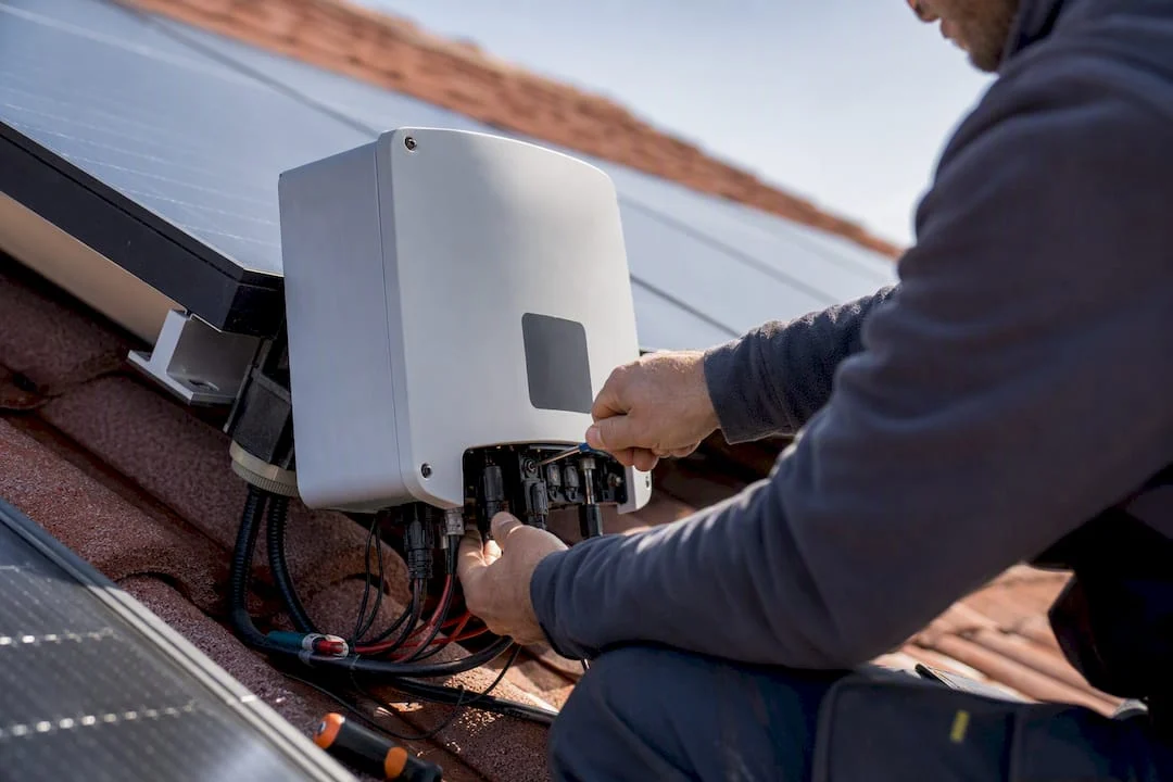 Tecnico che regola un inverter trifase sul tetto